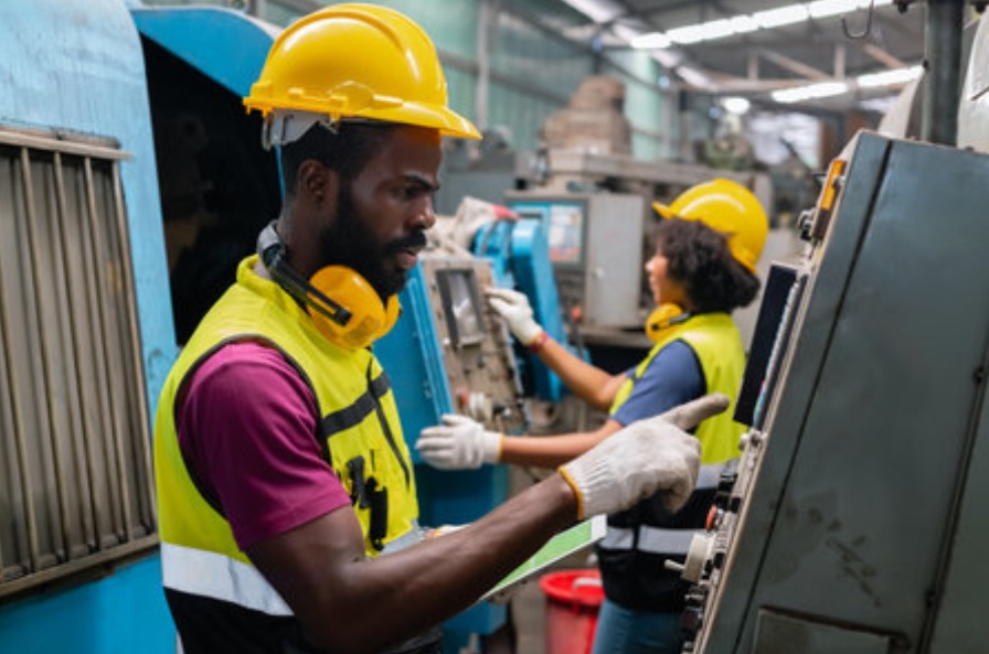 Industrial factory workers discussing operations; HR and staff outsourcing solutions for manufacturing in Ghana.